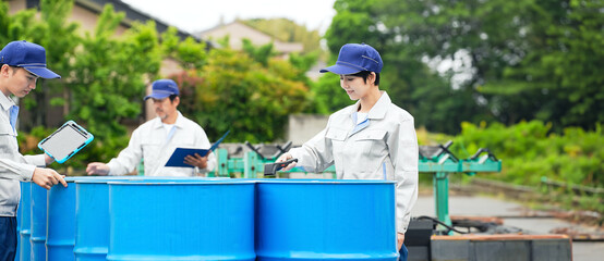 A group of workers inspecting drums