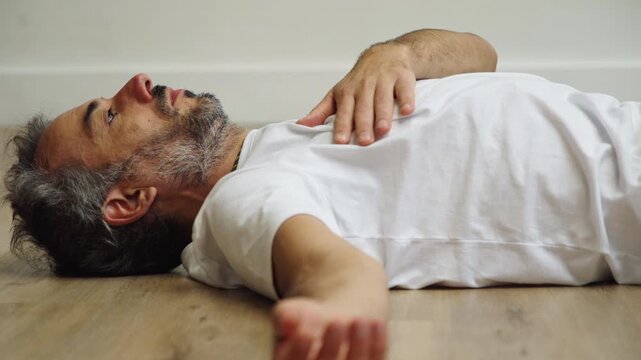 Man practicing twisting pose indoors with calm focus