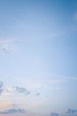 Clear evening sky with soft clouds scattered across the horizon, minimal and peaceful natural background in pastel blue tones