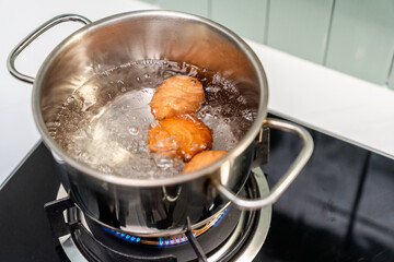 Boiled eggs in a pot. Chicken eggs boiling in saucepan on gas stove