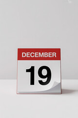 Desk Calendar Displaying December 19th on a White Table Against a Softly Lit Background for Office Use