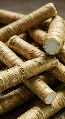 Photo of a pile of horseradish roots with brown texture and rough surface detail