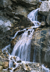 Waterfall cascading down a rugged rocky slope. The water appears silky and smooth.
