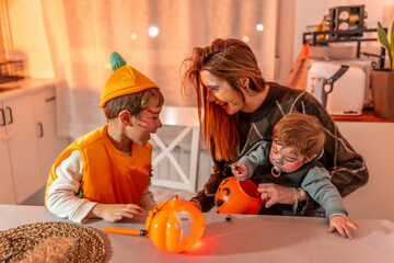 Family wearing halloween costumes playing with pumpkin baskets at home