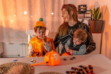 Mother and children wearing halloween costumes at home