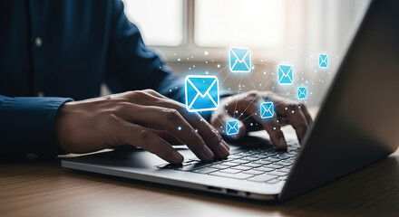 Hands type on a laptop keyboard as blue email icons glow and connect above