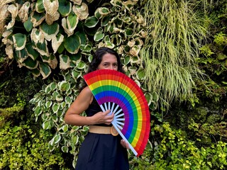 Woman with rainbow fan celebrating diversity and pride