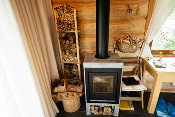 Cozy cabin interior showcasing a modern wood-burning stove with firewood storage