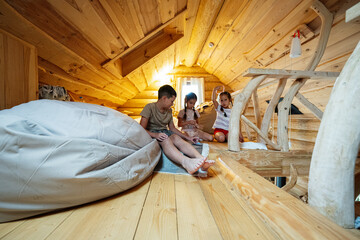 Wooden loft interior with children playing and relaxing
