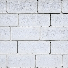 Obraz premium Plain white cinder block wall, exhibiting uniform texture and construction detail. Architectural view of a neutral exterior wall, showcasing construction materials.