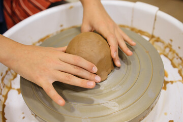 potter's wheel and girl's hands sculpting clay	