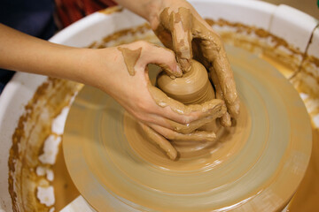 potter's wheel and girl's hands sculpting clay	