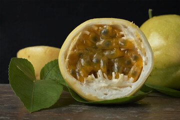 Juicy yellow passion fruit opened to reveal its vibrant pulp on a rustic table.