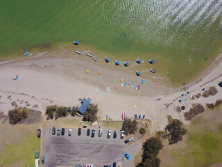 Aerial view of Kalbarri, Western Australia, showing a sandy riverfront beach with colorful kayaks...