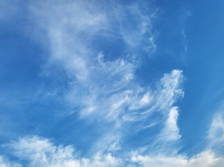 Vibrant Blue Sky with Wispy Clouds, clear blue sky filled with a variety of clouds. The upper part of the sky features thin, wispy cirrus clouds, while the bottom shows the fluffy tops of cumulus 