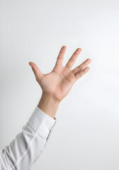 Naklejka premium A male hand in a white collared shirt extends outward, palm up, against a plain white background. Neutral hand gesture with plain backdrop.