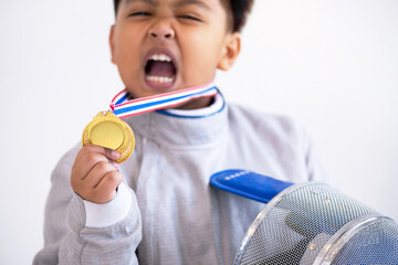 Boy fencer is happy with his victory, holding and showing off gold medals on white background,...