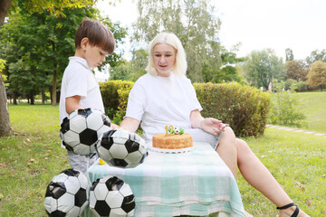Celebrating a Special Birthday Picnic With Cake and Soccer Balloons in a Sunny Park