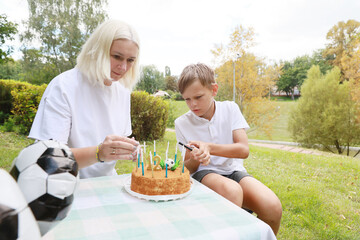 Celebrating a Joyful Birthday Outdoors With Cake Decorating and Fun Activities in a Vibrant Green Setting During a Sunny Day in the Park