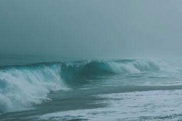 Fototapeta premium Serene Ocean Waves Rolling Gently on Foggy Beach at Dawn