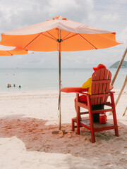 Lifeguard Sitting Under Umbrella on Sandy Beach