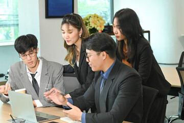 Business people having a serious meeting using laptop in the office