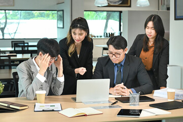 Business people having a serious meeting using laptop in the office