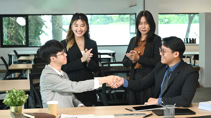 Businessman shaking hands with colleague after meeting in office