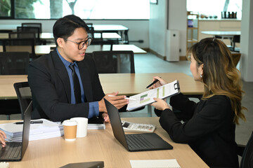 Two young colleagues working together at modern office
