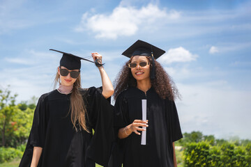 Happy Graduates Celebrating Graduation Day Outdoors, Smiling Female Students Celebrating Graduation...