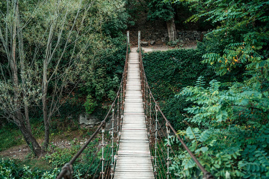 Fototapeta Old Suspension Bridge in the Forest. Adventure and Nature Concept