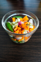 A close-up of fresh, colorful Indonesian pickled vegetables, or acar, in a glass bowl. A bright, healthy, and authentic food photo