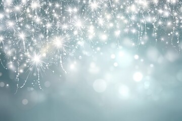 Sparkling, silvery fireworks cascading over a soft teal background