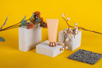 Plastic white tube for cream or lotion. Skin care or sunscreen cosmetic with stylish props on...