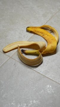 Garbage on the floor after a house party.
After party at home and uncleaned floor from garbage.
Banana peel from an eaten banana lies on the ceramic floor close-up