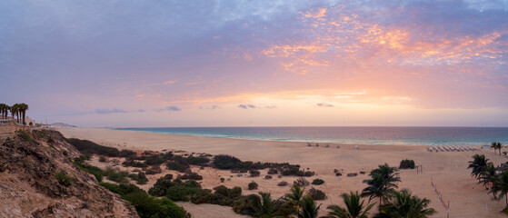 Panorama of a sandy beach,luxury resort,parasol,palm trees and turquoise Atlantic Ocean at amazing...