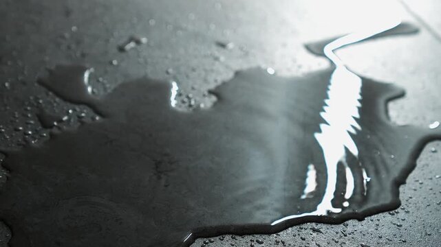 a stream of water pours from the ceiling onto the floor during a flood.
A puddle of water on the floor into which drops of water fall from above.
A large puddle on a ceramic floor in a house