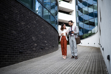 Business people walking and talking outside office building