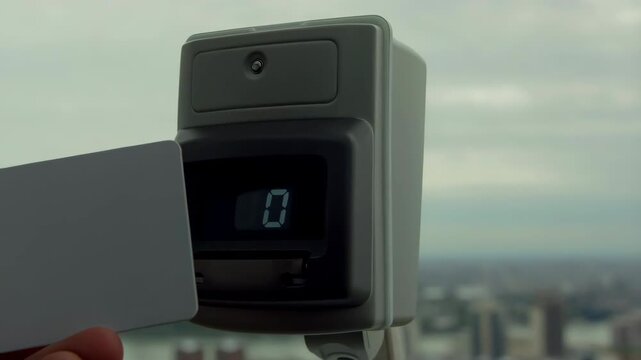 Tourist using binoculars with credit card payment in london