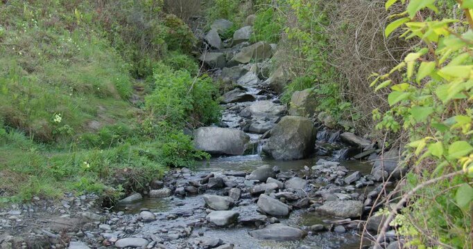 wide shot of a small rocky stream brook at new quay beach