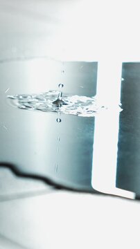 A leaking roof and water pouring onto the floor creating a large puddle.
A puddle on the floor and drops of water flowing down.
Splashes of water hitting the puddle.
Puddle, water, streak, leak