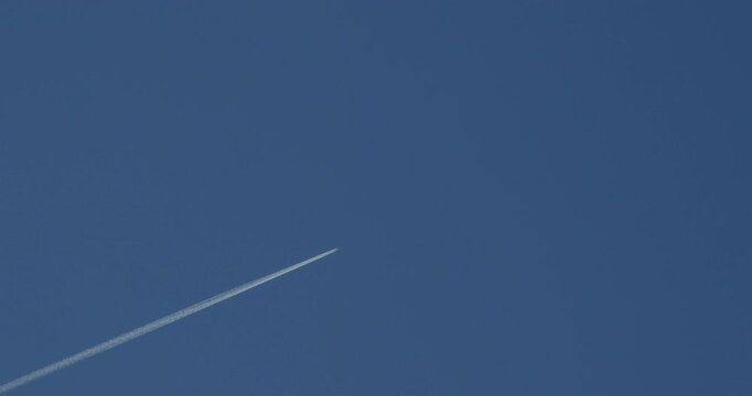 Shot of a plane vapour trail, contrail at Cardigan Bay on new quay beach