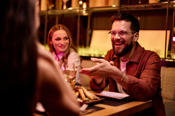 Friends Enjoying Lively Conversation and Drinks at an Upscale Restaurant