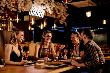 Friends Enjoying Dinner Together at a Trendy Sushi Restaurant in the Evening