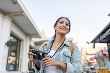 Asian young beautiful woman backpacker exploring the city outdoors.