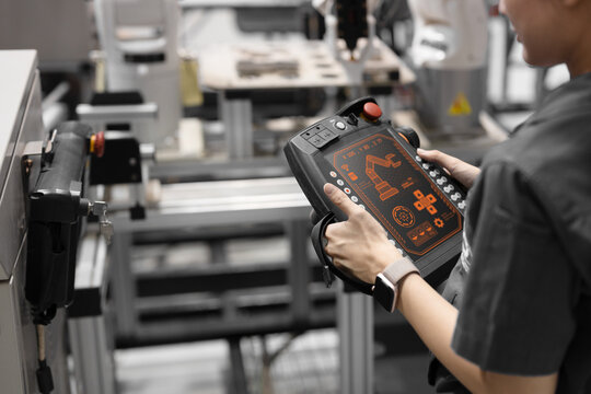 Closeup engineer using industry robot setup operate control by remote control in plant factory
