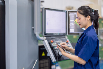 young technician engineer worker with CNC lathe metal machine in modern steel industry factory
