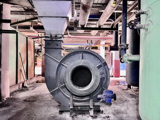 Industrial centrifugal fan blower inside factory plant, used for ventilation, air circulation, and mechanical engineering in heavy industry environment.
