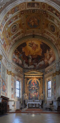 Obraz premium The elaborate interior of a historic Italian church, featuring a richly decorated altar and a magnificent vaulted ceiling covered in Renaissance frescoes.