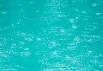 A body of water with raindrops falling on it